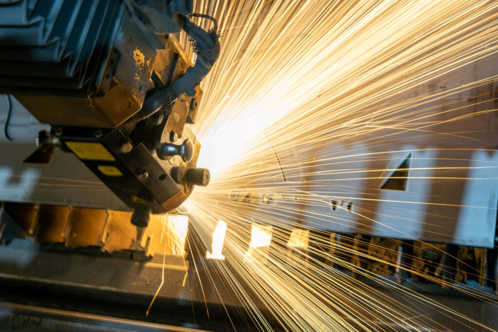 Metalworking machine sparks bright golden light in modern high-tech industrial factory wallpaper