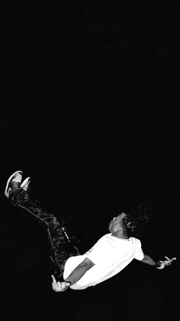 Dynamic Monochrome Wallpaper: Airborne Figure on Dark Background