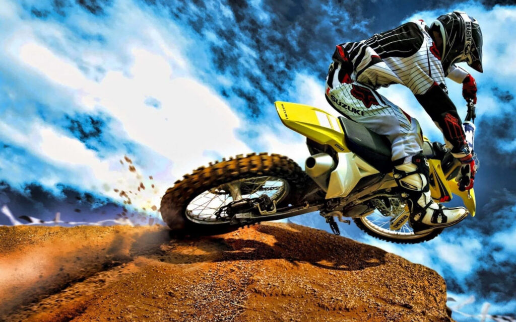 Dynamic Motocross Rider Wallpaper: Action-Packed Rugged Terrain Scene