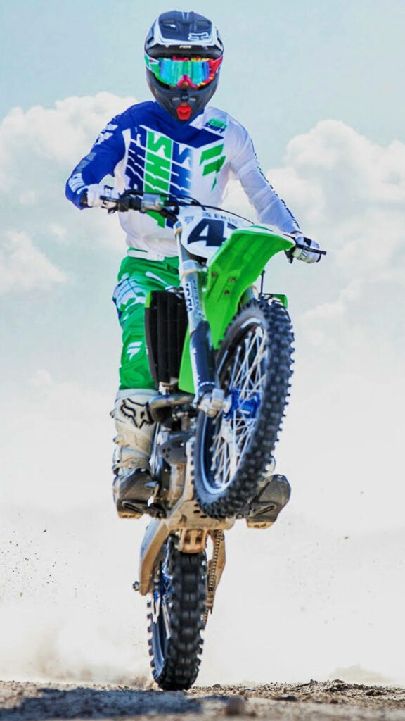 Dynamic Motocross Wallpaper: Rider Performing Wheelie in Vivid Colors
