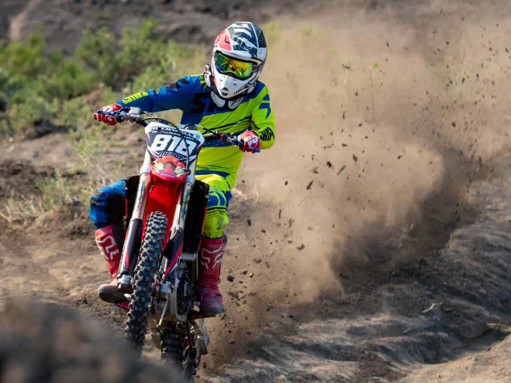 Dynamic Wallpaper: Ornery Biker in Action on Rugged Terrain