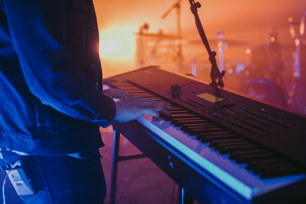 Dynamic Musician Wallpaper: Synthesizer Performance in Dramatic Light