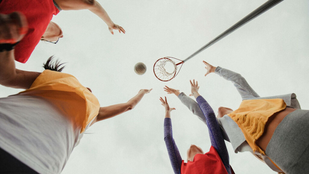 Dynamic Netball Action: Teen Girls Reaching for the Score - Wallpaper