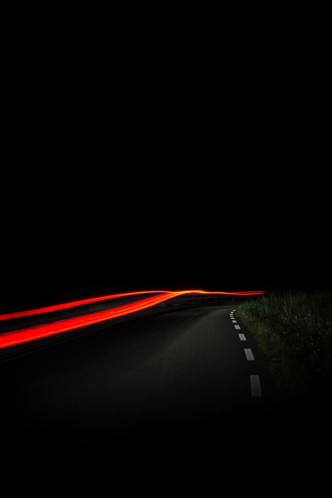 Nighttime road with red and yellow light trails highlighting motion and solitude wallpaper background