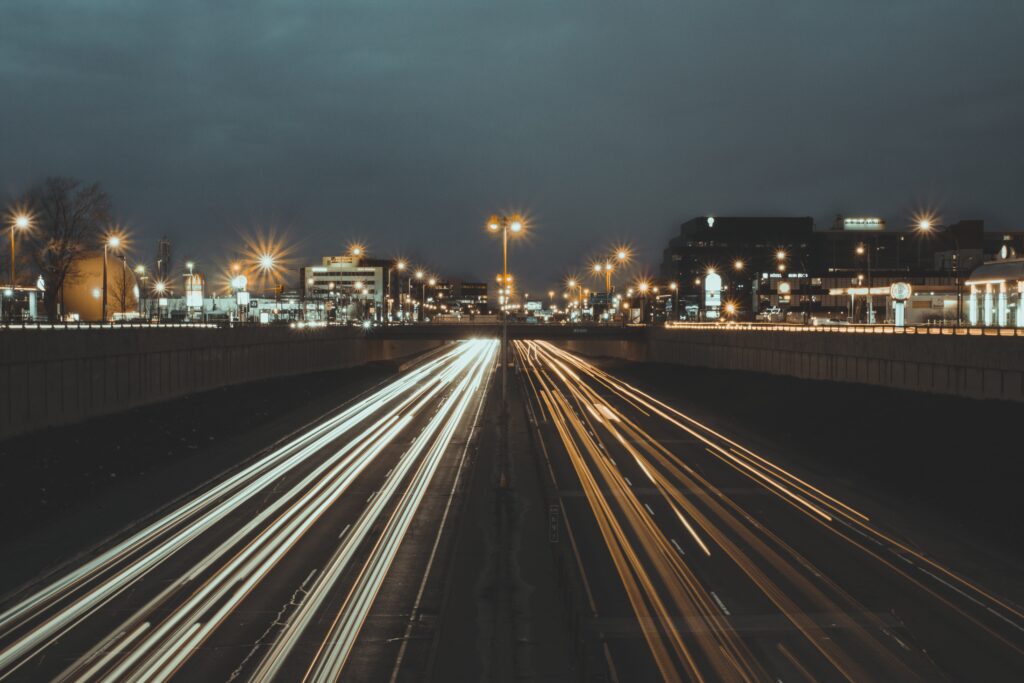 Dynamic Nighttime Cityscape Wallpaper: Energetic Urban Road & Bridge