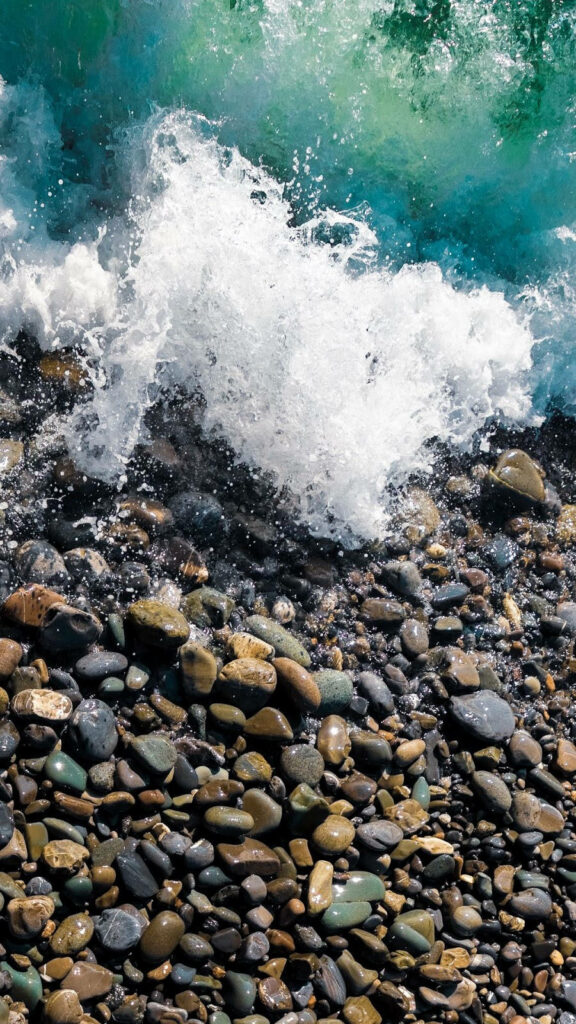 Vibrant Ocean Waves Crashing on Colorful Rocks - Dynamic Wallpaper