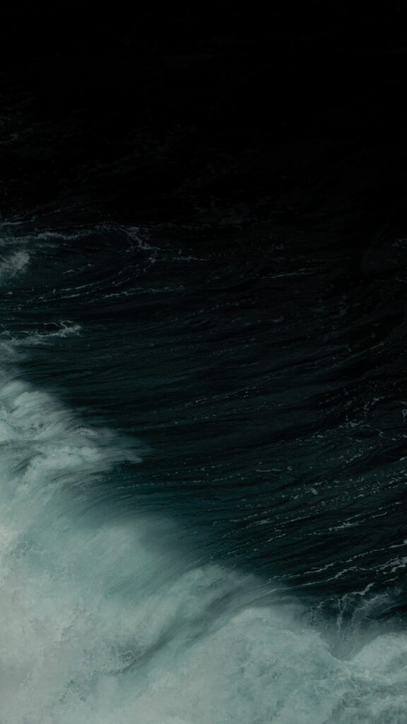 Powerful ocean wave with swirling textures and deep blue water minimalist dramatic wallpaper background