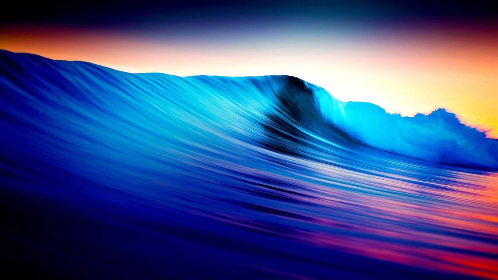 4K Ultra HD wallpaper of a powerful blue ocean wave curling at sunset with orange purple hues