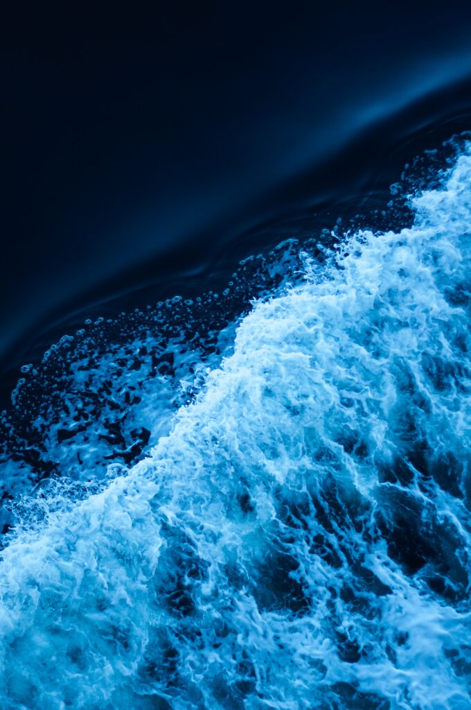 Close-up of dynamic blue ocean waves with white foam capturing energetic surf motion wallpaper
