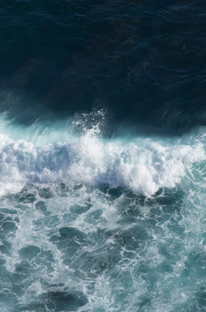 High definition wallpaper of vibrant ocean waves crashing with turquoise and deep blue hues