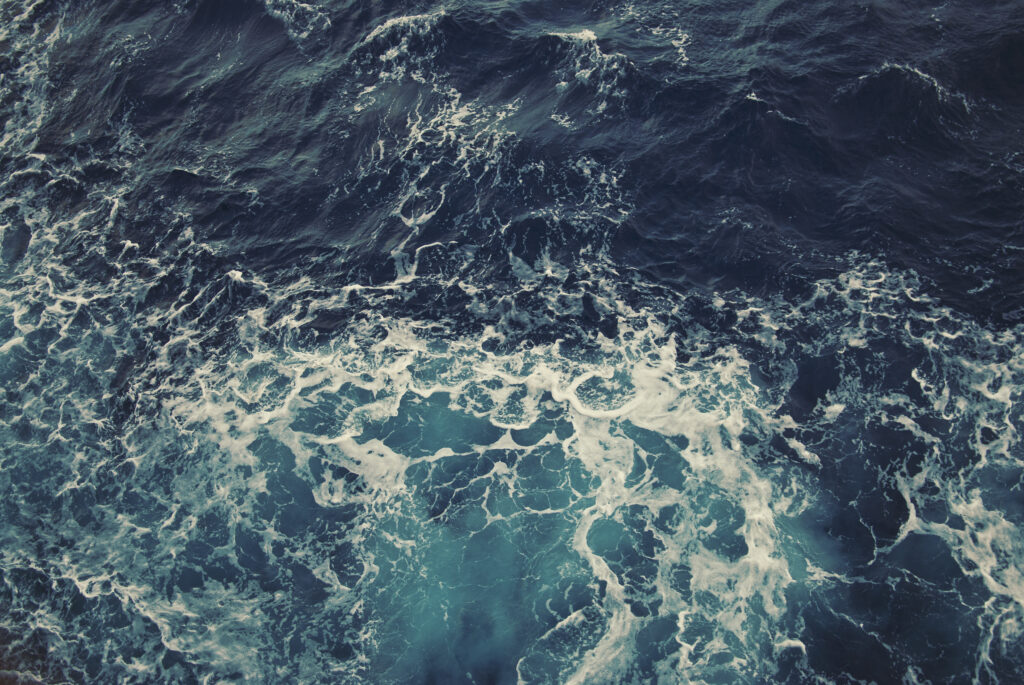 Dynamic ocean wallpaper with deep blue turquoise waves and frothy foam for serene backgrounds