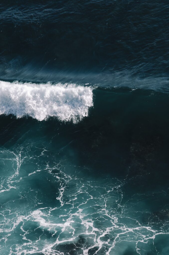 Dynamic ocean waves wallpaper with rolling foamy water in deep blue and turquoise tones