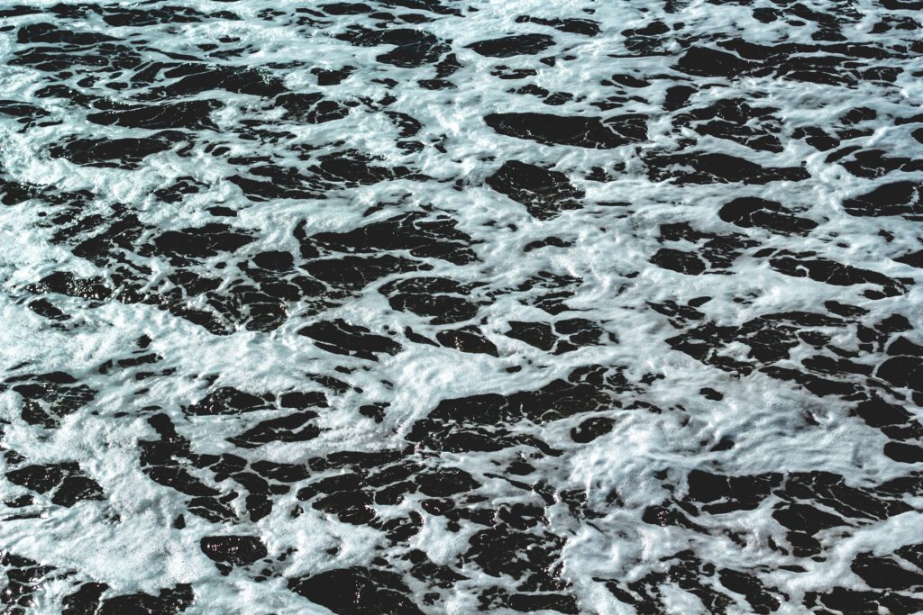 High-resolution ocean waves wallpaper with foamy white crests and dynamic deep blue water texture