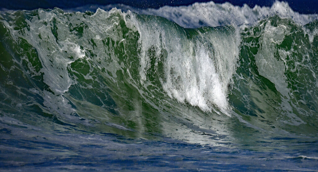 Dynamic ocean waves crashing with white foam in vibrant blue and green high-resolution wallpaper