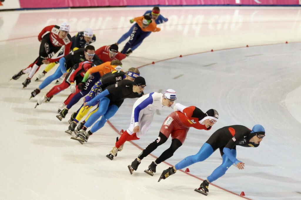 Dynamic Olympic Short Track Speed Skaters Wallpaper Background