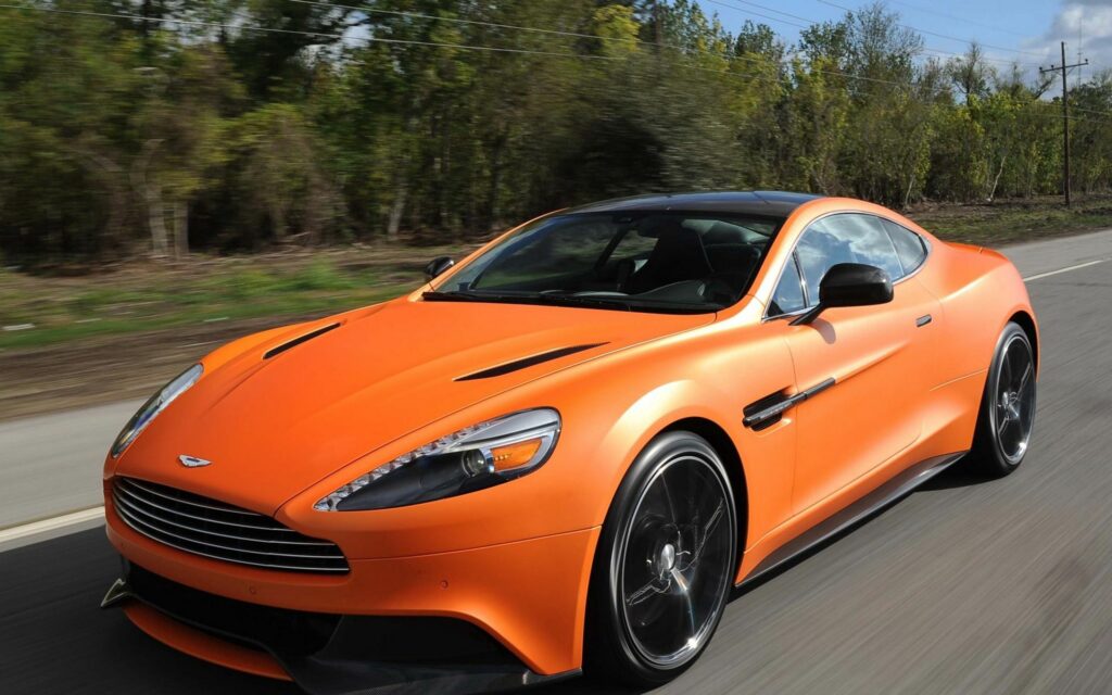 Orange Aston Martin Vanquish: Dynamic Wallpaper on Scenic Road