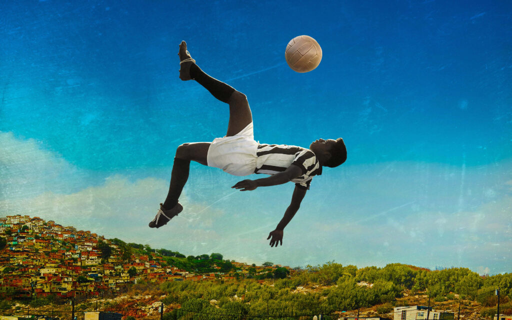 Pelé's Acrobatic Soccer Move Wallpaper in Vibrant Favela Landscape