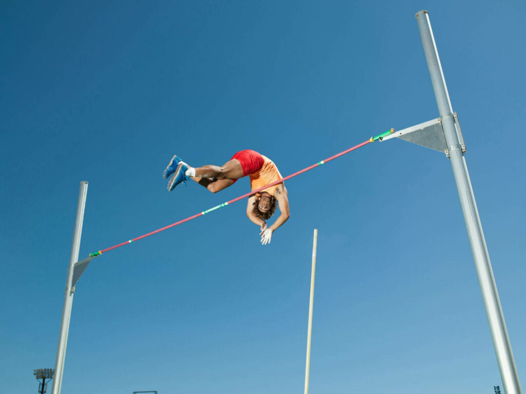 Dynamic Male Pole Vault Wallpaper: Strength & Agility in Action