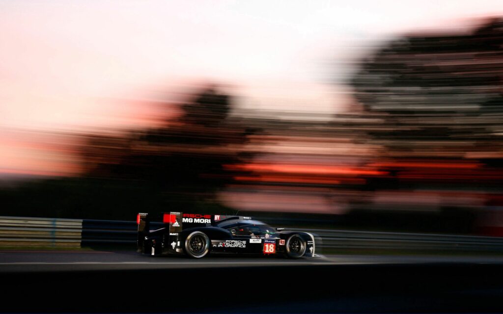 Porsche Racing at Le Mans: Dynamic Sunset Wallpaper with Motion Blur