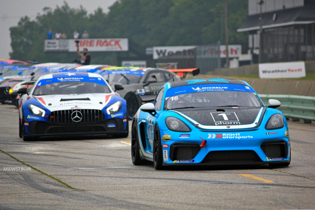 Thrilling Racing Scene: Blue Porsche Cayman Leads Performance Cars Wallpaper