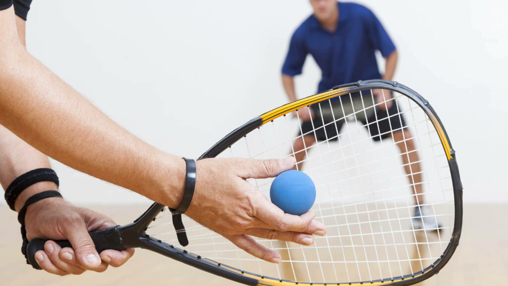 Intense Racquetball Match Wallpaper: Player Prep & Defense Close-Up