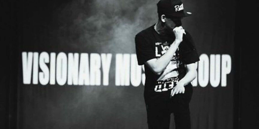 Dynamic Rapper on Stage - Visionary Music Group Monochrome Wallpaper