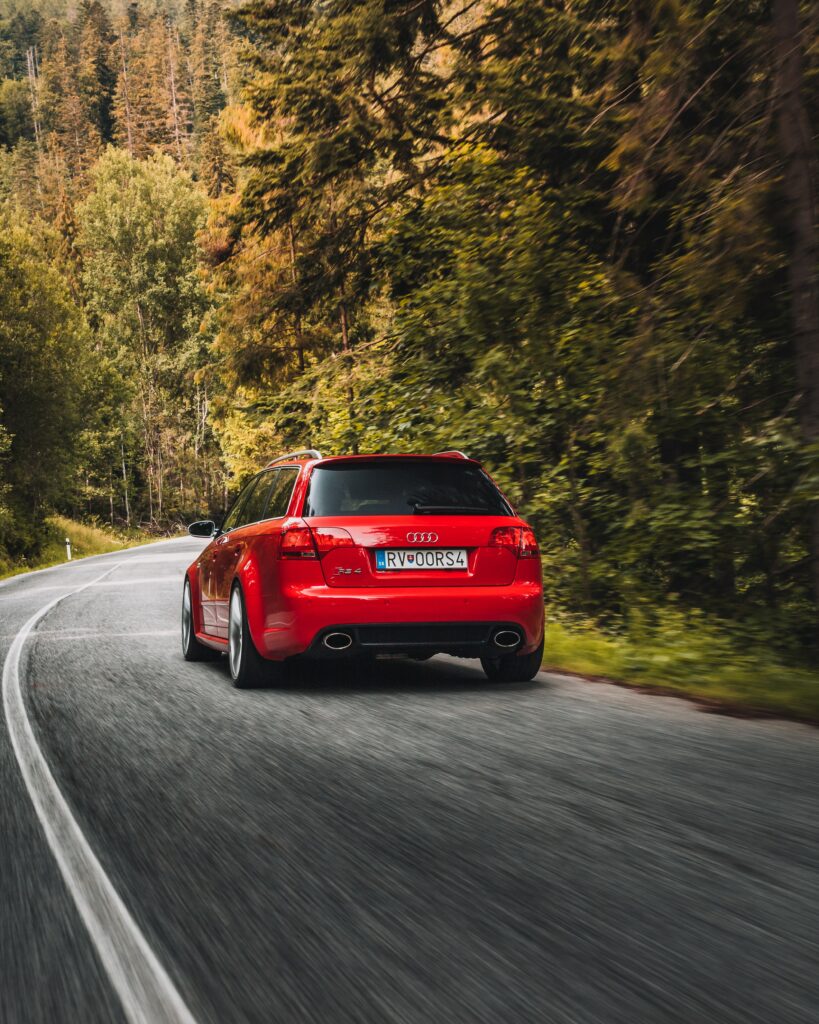 Red Audi RS4: Dynamic Scenic Drive Wallpaper Background