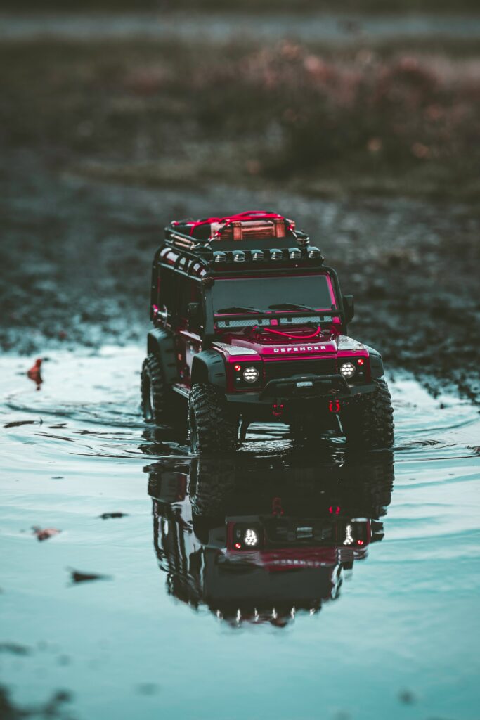 Dynamic Red Toy SUV Splashing Through Puddle - Adventure Wallpaper