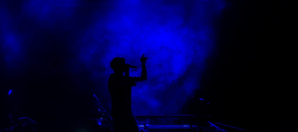 Dynamic Singer Silhouette Wallpaper with Blue Smoke Background