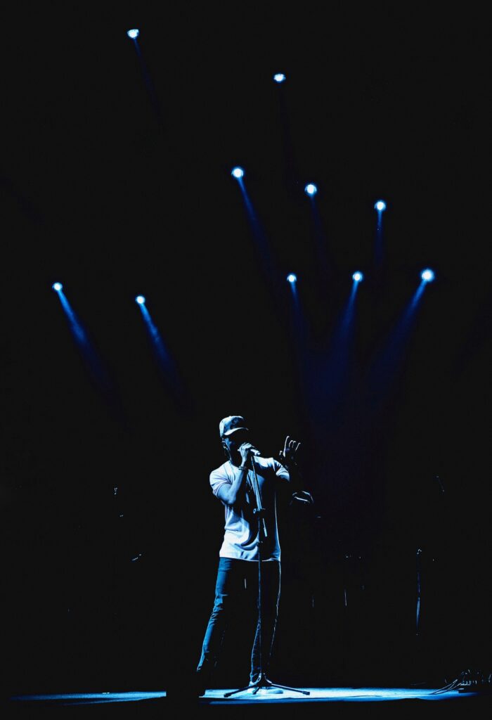 Dynamic Wallpaper of Singer Performing in Dramatic Spotlight