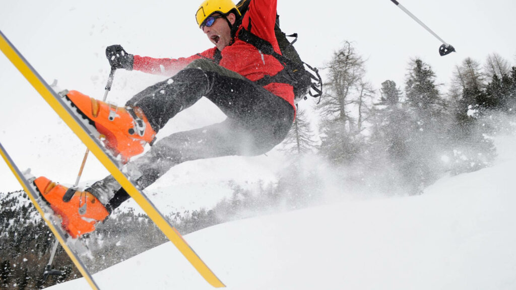 Dynamic Wallpaper: Skier Mid-Air in Dramatic Winter Landscape
