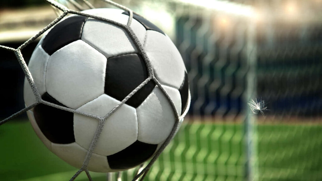 Vibrant Soccer Wallpaper: Ball Hitting Net on Green Field