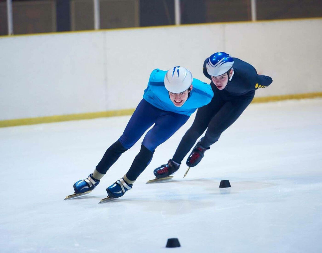 Dynamic Speed Skater Wallpaper: Intense Ice Racing Turn Background