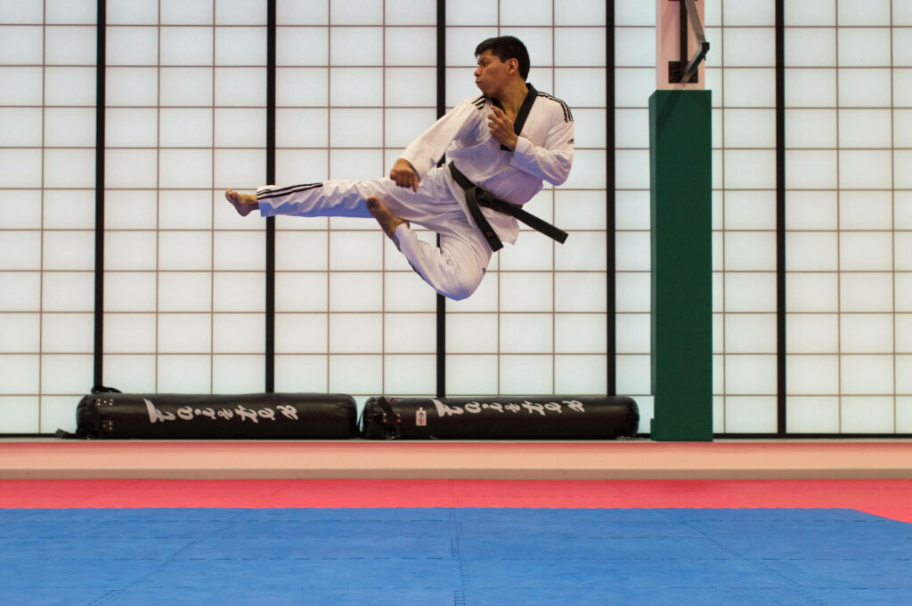 Dynamic Taekwondo Jump Kick Wallpaper: Mastery in Martial Arts
