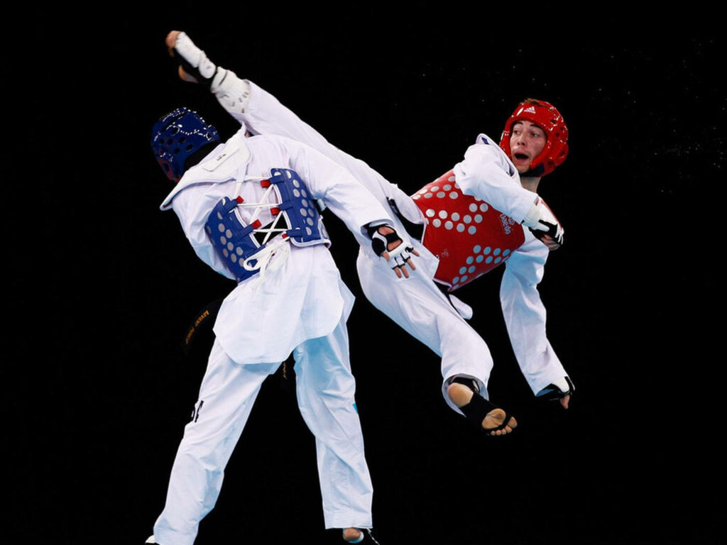 Dynamic Taekwondo Wallpaper: Mid-Air Reverse Side Kick Moment