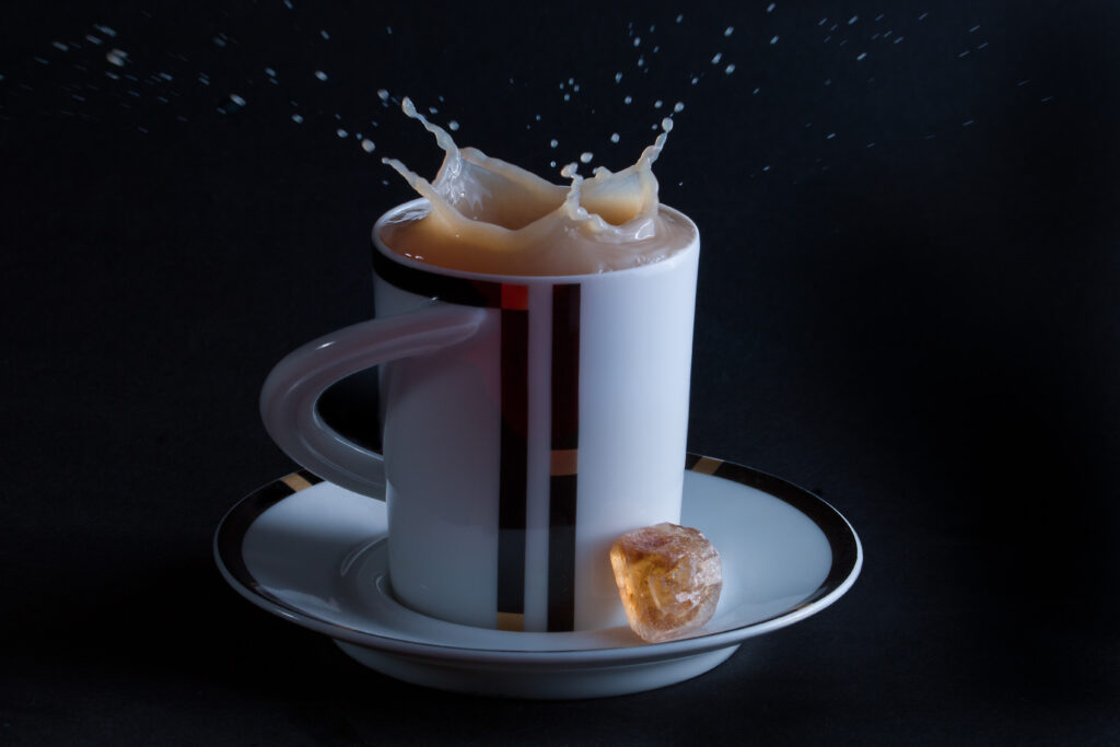 Dynamic Tea Splash Wallpaper with Ice Cubes in Stylish Cup & Saucer
