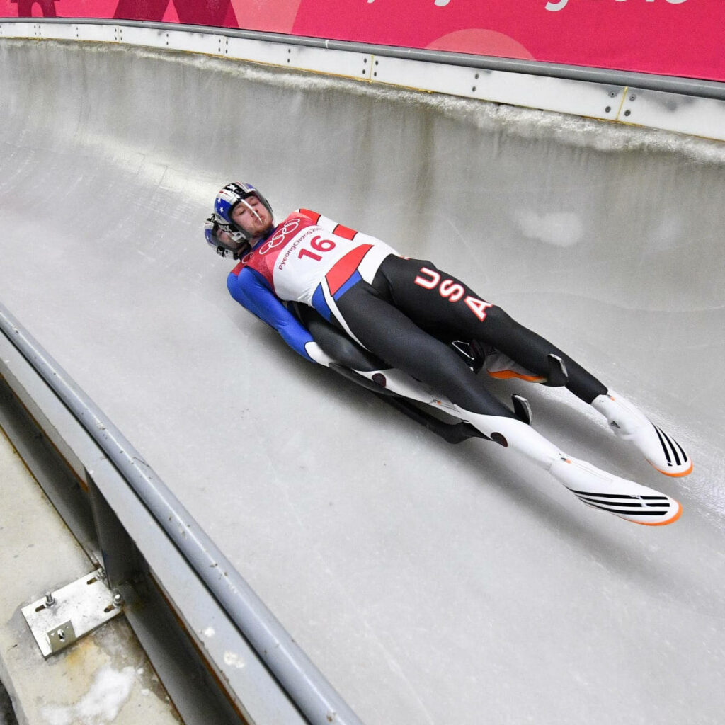 Team USA Luge Athletes in Action: Thrilling Dynamic Wallpaper