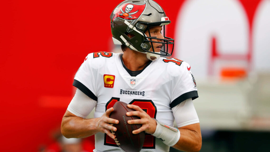 Tom Brady Wallpaper: Intense Buccaneers Legend with Football Background