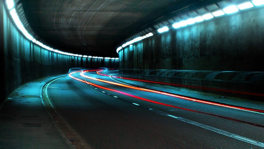 Dynamic Underground Tunnel Wallpaper: Curved Road with Fluorescent Lights