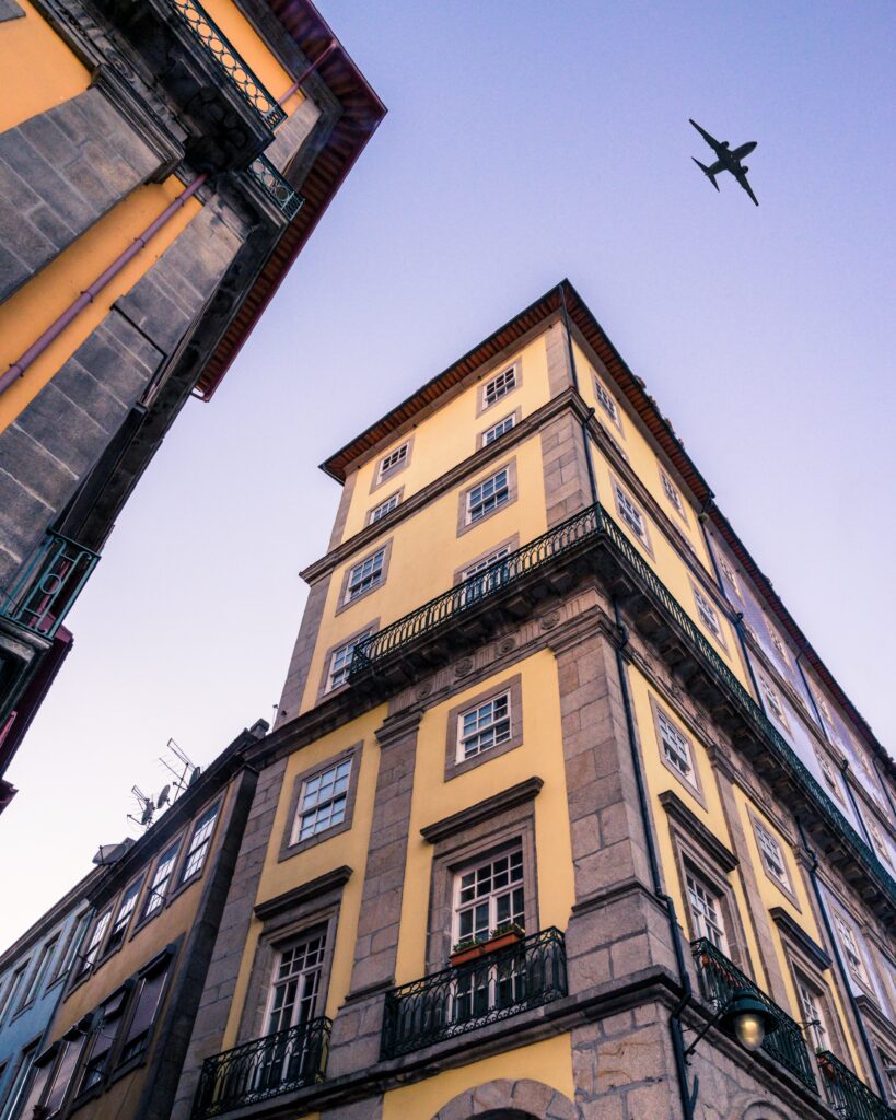 Vibrant Yellow Building Facade Wallpaper with Airplane Silhouette
