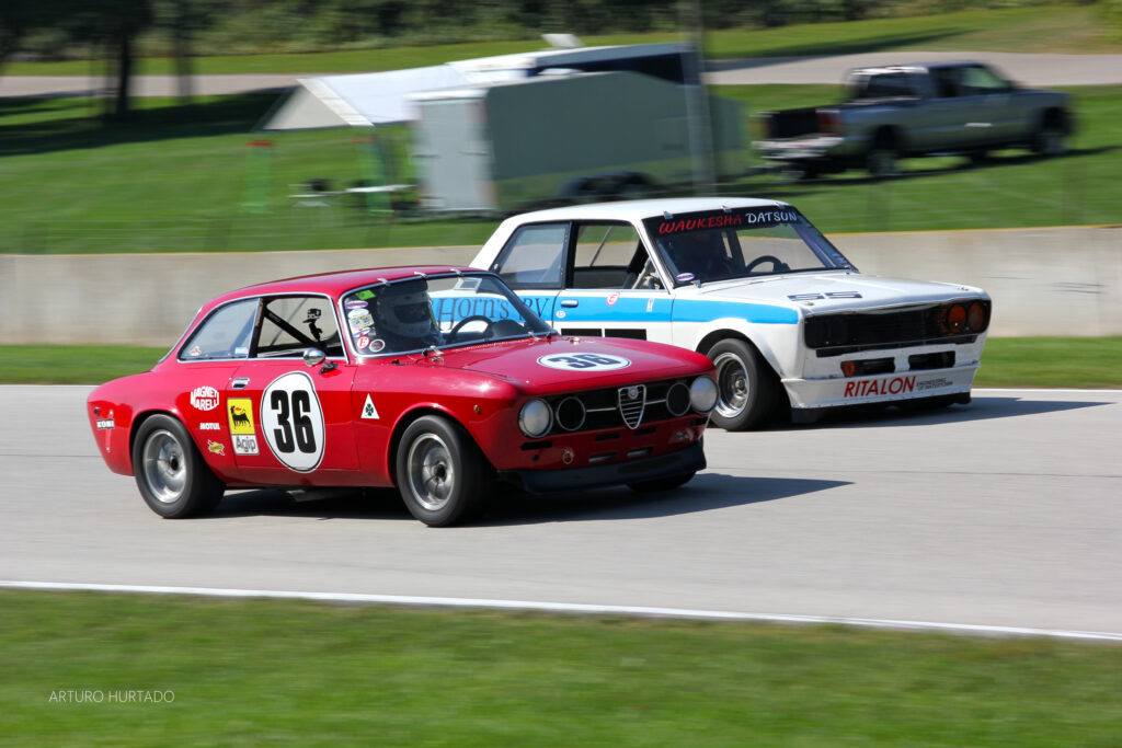 Vintage Racing Scene: Red #36 vs. Classic Blue Car on Track Wallpaper