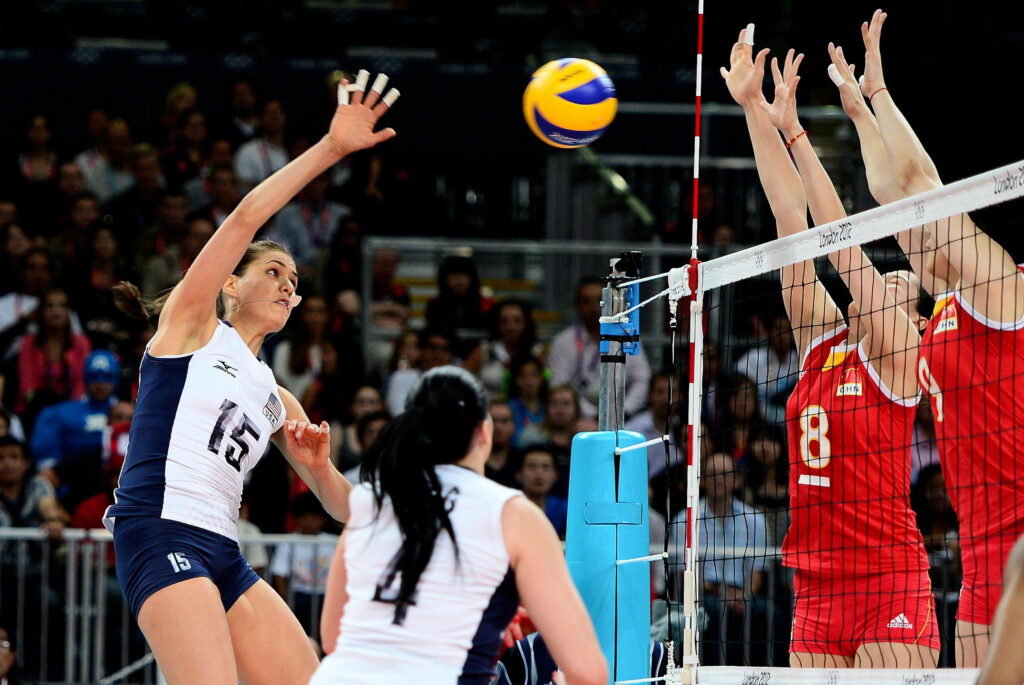Dynamic Indoor Volleyball Spike: Blue vs Red Action Wallpaper