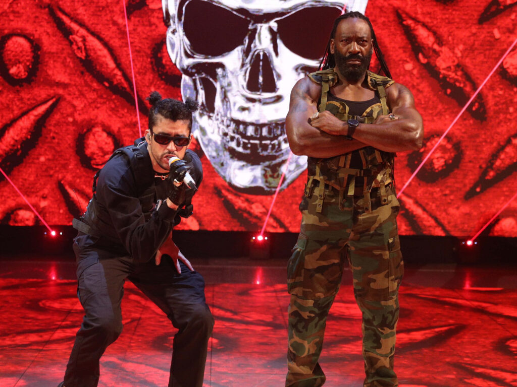 WWE wallpaper Bad Bunny and Booker T high-energy hip-hop style camo military vivid red skull background