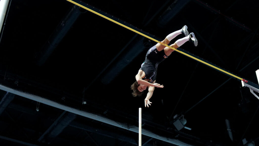 Armand Duplantis Mid-Air: Dynamic Pole Vault Wallpaper Background