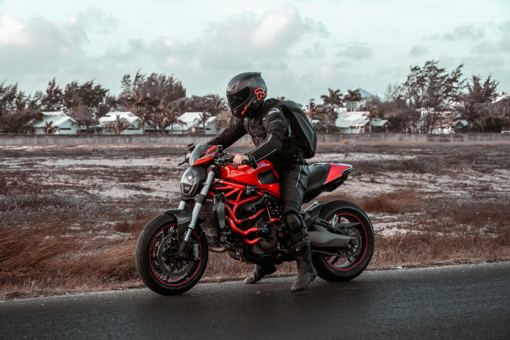 Adventure Wallpaper: Bike Rider on Red Motorcycle in Scenic Fields