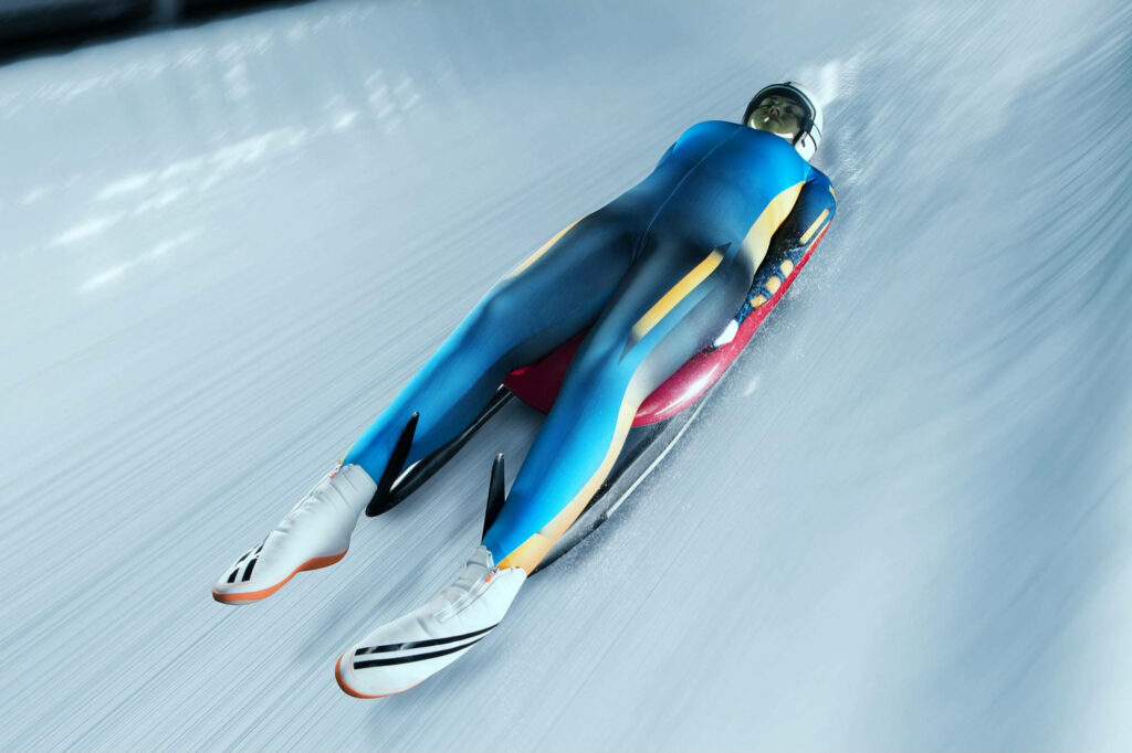Dynamic Luge Athlete Wallpaper: Female in Blue Sporting Precision