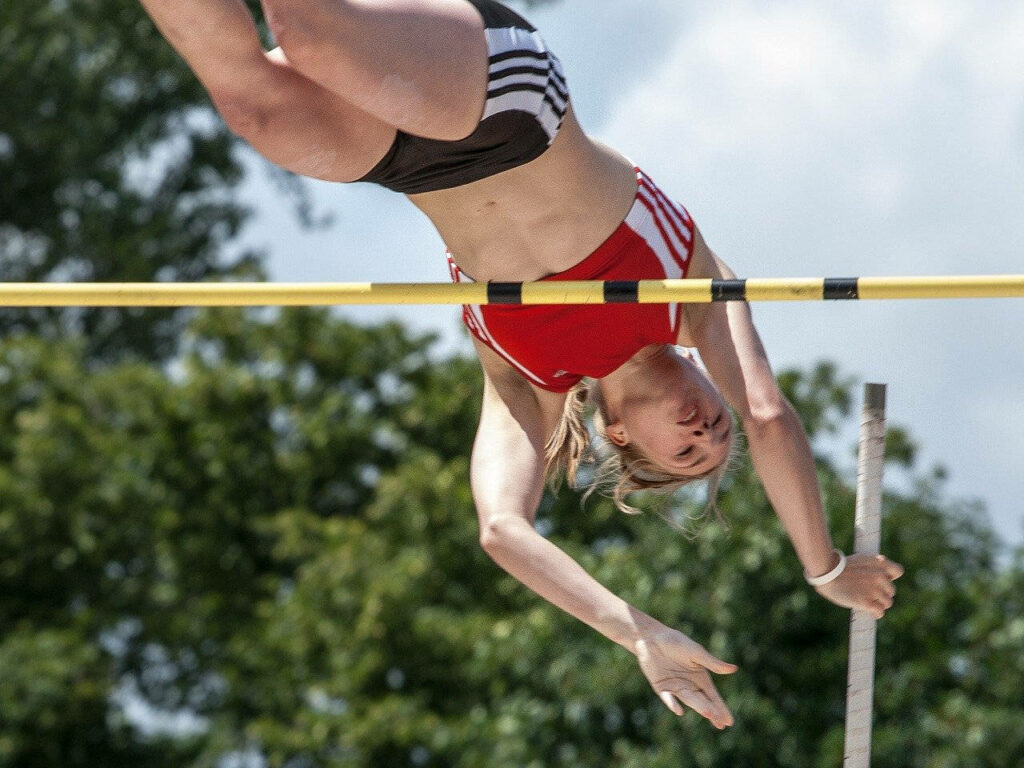 Dynamic Female Pole Vaulter Wallpaper: Strength in Nature