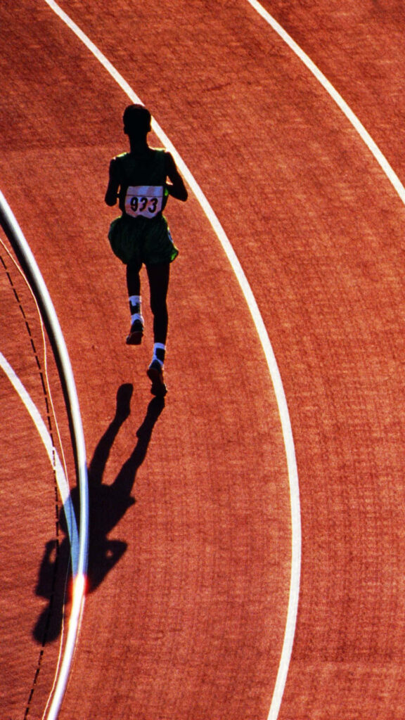 Dynamic Running Wallpaper: Man on Curved Track in Sunlight