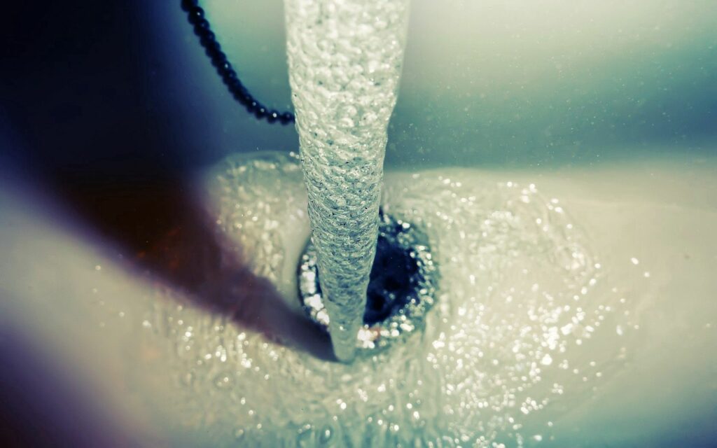 Dynamic Water Flow: Refreshing Jet Sink Wallpaper Background