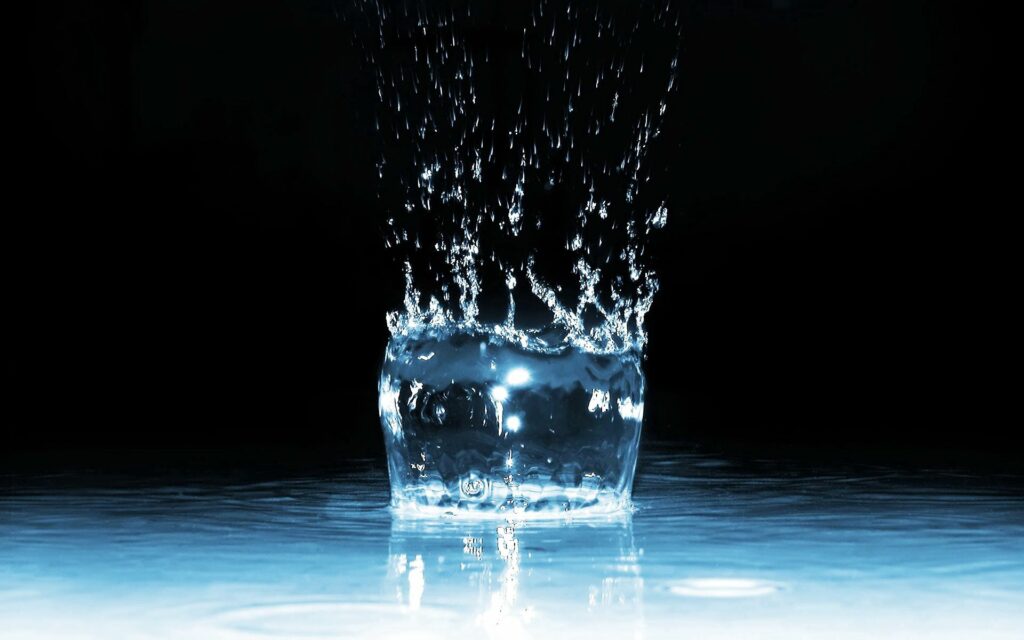 Dynamic Water Splash Wallpaper: Fluid Motion on Dark Background